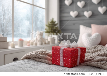 Gift wrapped with gold ribbon placed on bed. Beautifully wrapped red paper gift box rests gently on a bedroom interior. Christmas, New year winter holiday vibe. Morning surprise. Delivery service 134341916