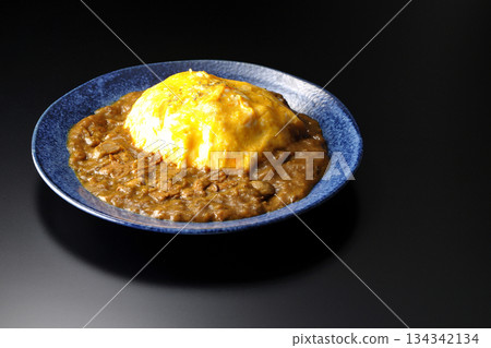 Omelet curry rice photographed against a black background 134342134