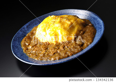 Omelet curry rice photographed against a black background 134342136