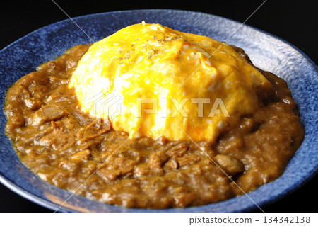 Omelet curry rice photographed against a black background Omelet curry rice photographed against a black background 134342138