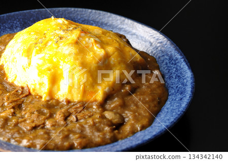 Omelet curry rice photographed against a black background 134342140