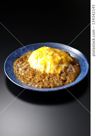 Omelet curry rice photographed against a black background Omelet curry rice photographed against a black background 134342145