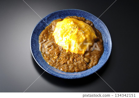 Omelet curry rice photographed against a black background Omelet curry rice photographed against a black background 134342151