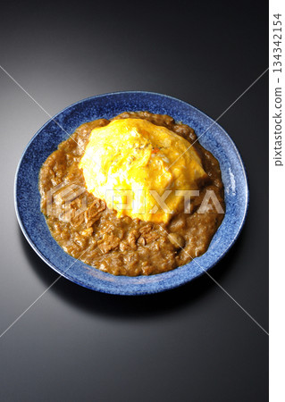 Omelet curry rice photographed against a black background 134342154