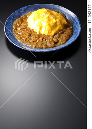 Omelet curry rice photographed against a black background 134342165