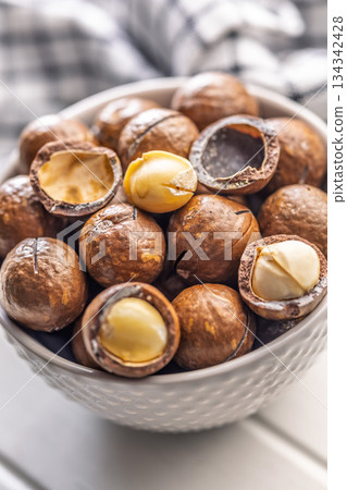 Tasty macadamia nuts in bowl on white table. 134342428