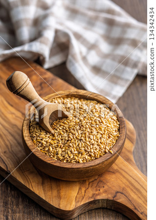Golden linseed or flaxseed. Healthy flax seed in bowl on wooden table. 134342434
