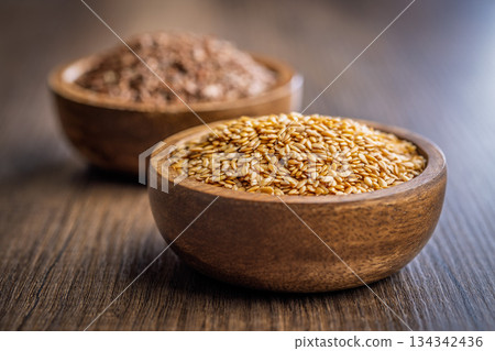 Golden linseed or flaxseed. Healthy flax seed in bowl on wooden table. Golden linseed or flaxseed. Healthy flax seed in bowl on wooden table. 134342436