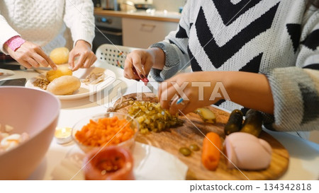 Team collaborates on meal preparation with scattered utensils Team collaborates on meal preparation with scattered utensils 134342818