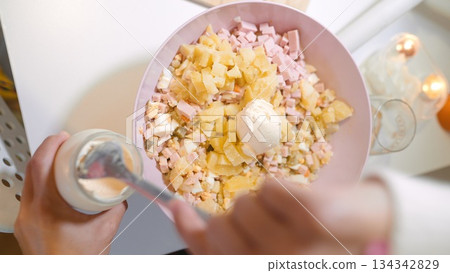 Crafting customary salad with ham under gentle lighting conditions Crafting customary salad with ham under gentle lighting conditions 134342829