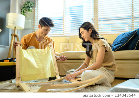 Photo series of young asian couple assembly a new furniture at home 134343544