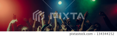 Energetic party crowd with raised hands under colorful stage lights. Banner Energetic party crowd with raised hands under colorful stage lights. Banner 134344152