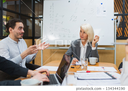 Teamwork brainstorm. Coworkers cooperating working together at office meeting. Colleagues discussing project ideas. Group of people in creative office discussing business. Young professional team 134344190