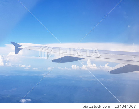 Airplane wing above clouds window view blue sky horizontal 134344308