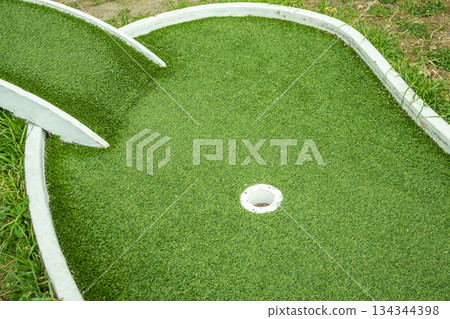 Mini golf lane with artificial turf and hole horizontal 134344398