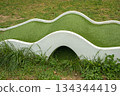 Mini golf lane with wavy hills and tunnel horizontal 134344419