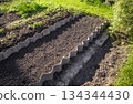 Prepared garden bed with loose soil and wavy concrete edging horizontal 134344430