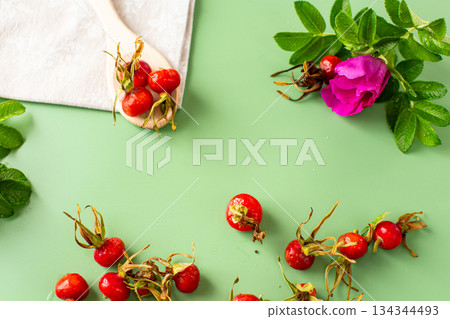 green background and red rose hips green background and red rose hips 134344493