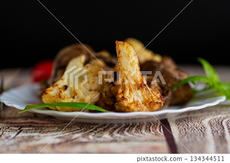 Delicious baked cauliflower and mushrooms with fresh basil garnish Delicious baked cauliflower and mushrooms with fresh basil garnish 134344511