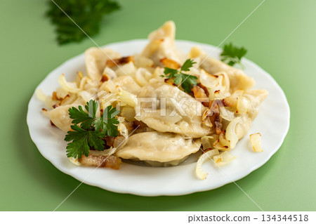 Rustic dumplings with caramelized onions and fresh parsley garnish Rustic dumplings with caramelized onions and fresh parsley garnish 134344518