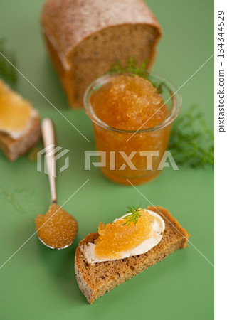 Appetizing fish roe on toast and spoon in minimal green studio setup 134344529