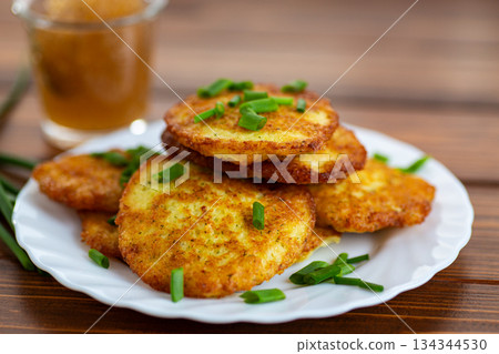 Traditional potato pancakes with fresh herbs on wooden table 134344530