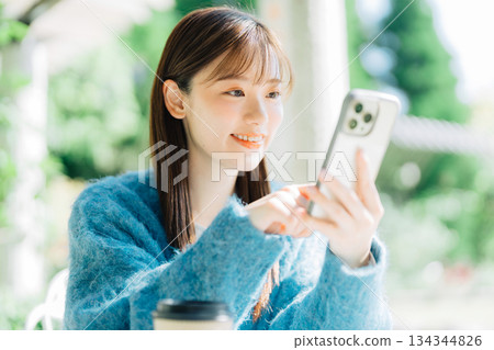 Woman looking at smartphone on terrace 134344826
