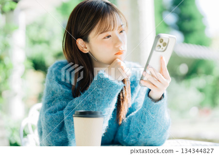 在露台上看智慧型手機的女人 134344827