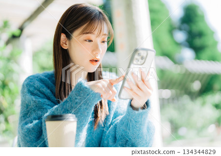Woman looking at smartphone on terrace 134344829