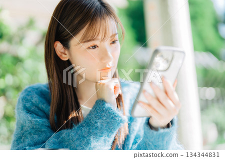 在露台上看智慧型手機的女人 134344831