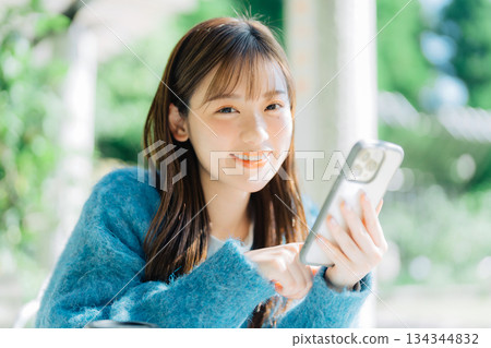 在露台上看智慧型手機的女人 134344832