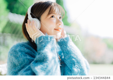 Young woman listening to music on the terrace 134344844