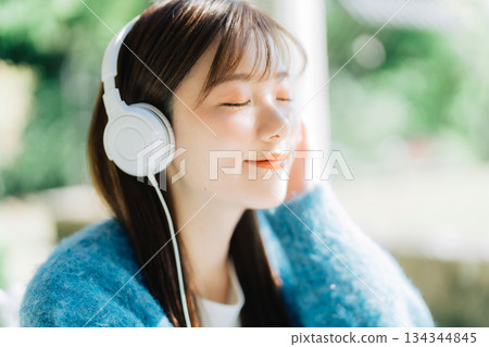 Young woman listening to music on the terrace 134344845