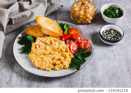 Vegetarian chickpea puree with vegetables on a plate on the table 134345238