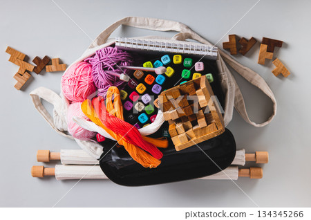 Close up of a tote bag with craft and leisure items on a table top view Close up of a tote bag with craft and leisure items on a table top view 134345266