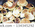 Photo of browned potatoes fried in a frying pan 134345292