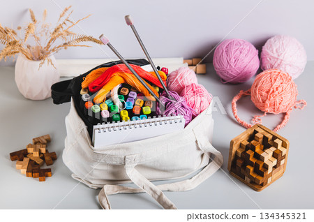 Analog bag of yarn, markers, a notebook, knitting needles, and puzzles for a digital detox Analog bag of yarn, markers, a notebook, knitting needles, and puzzles for a digital detox 134345321