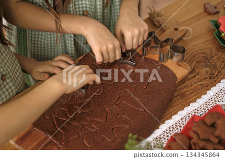 Children carve Christmas figures out of ginger dough and cookies. Festive preparations for Christmas and New Year Children carve Christmas figures out of ginger dough and cookies. Festive preparations for Christmas and New Year 134345864