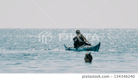 Fisherman Rowing Boat Sea - A lone fisherman rows a small boat through choppy waters on a cloudy day. Fisherman Rowing Boat Sea - A lone fisherman rows a small boat through choppy waters on a cloudy day. 134346240