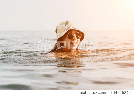 Woman Sunglasses Sea - A woman wearing sunglasses swims in the sea on a sunny day. Woman Sunglasses Sea - A woman wearing sunglasses swims in the sea on a sunny day. 134346244