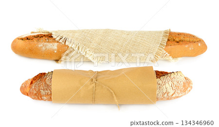 Two Freshly Baked Baguettes Wrapped in Paper and Burlap on White Two Freshly Baked Baguettes Wrapped in Paper and Burlap on White 134346960