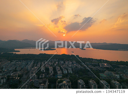 Aerial view of an orange sunset over West Lake and Hangzhou city with distant mountain. 134347119