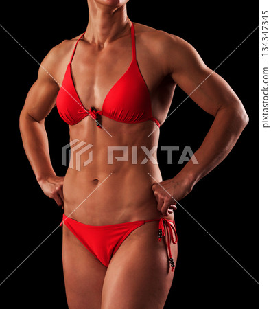 Muscular female body against black background. Muscular female body against black background. 134347345