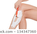 Woman shaving her legs, isolated on white background. 134347360