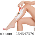 Woman shaving her legs, isolated on white background 134347370