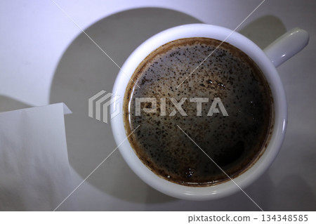 A coffee cup with a piece of paper. A coffee cup with a piece of paper. 134348585