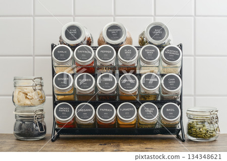Assorted spices in glass jars with metal lids 134348621