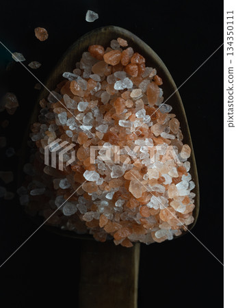 View of Pink Himalayan Salt with Bright colors textured surface on Wooden scoop with the dark background. 134350111