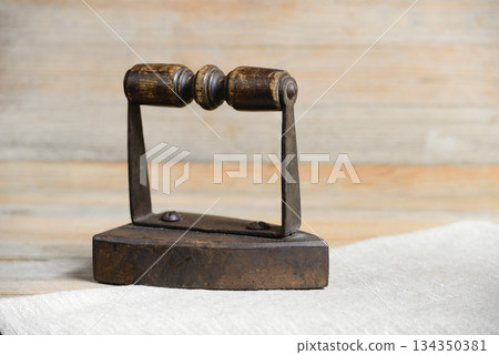 an antique iron tool with a wooden roller handle 134350381