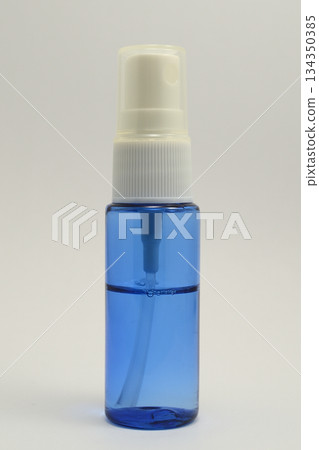 a small transparent spray bottle filled with blue liquid 134350385